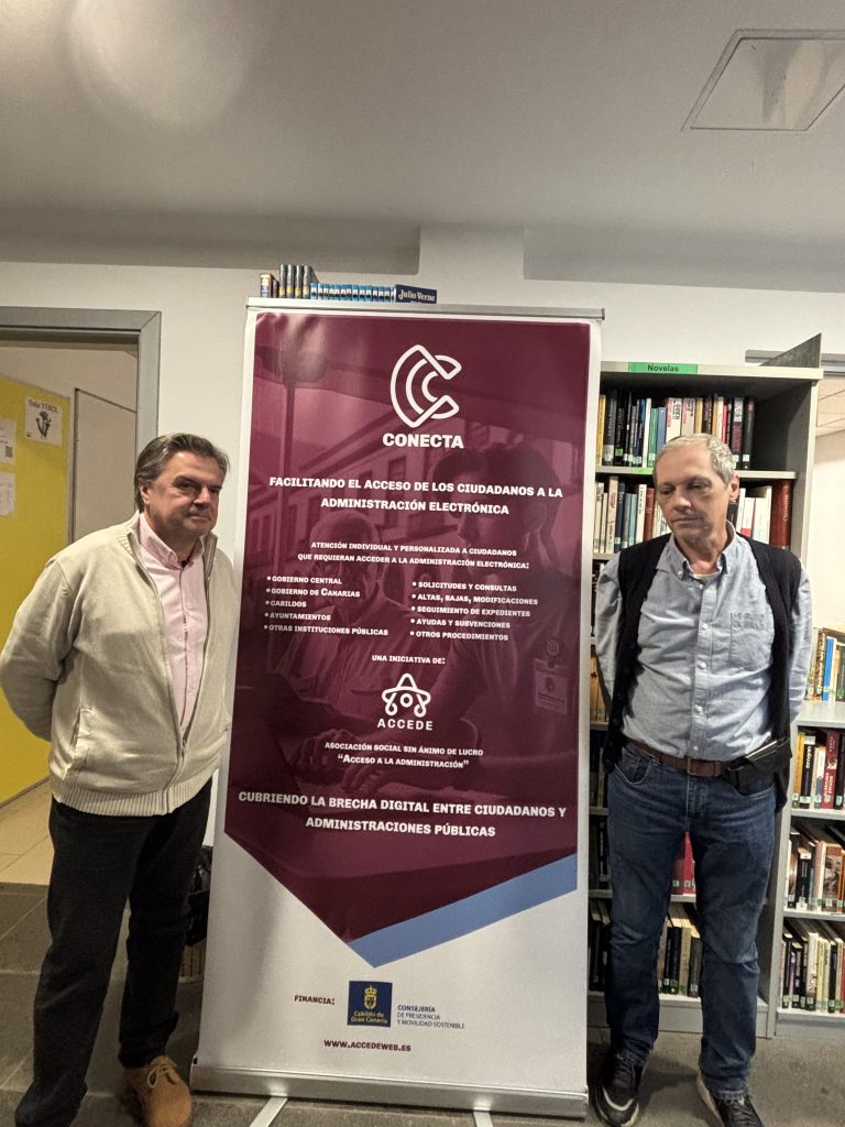 Dos representantes de asociaciones posan junto a un cartel informativo del proyecto Conecta, una iniciativa que facilita el acceso de los ciudadanos a la administración electrónica mediante asistencia personalizada en trámites administrativos. La imagen refleja el compromiso con la inclusión digital y la colaboración entre Conecta y diversas asociaciones locales.